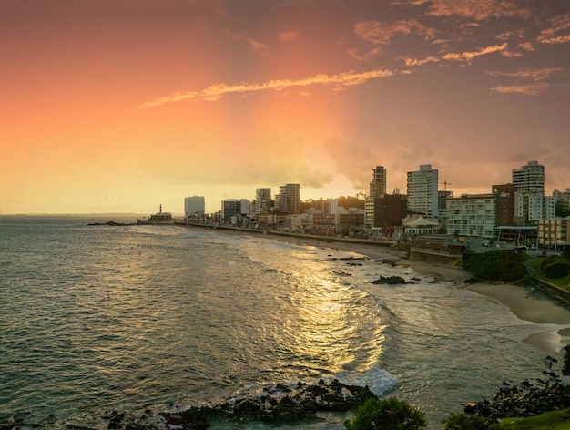 La puesta de sol en la playa de Barra en Salvador Bahia con el faro de Barra en el fondo