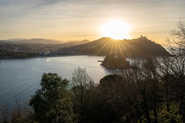 Foto la puesta de sol en la playa de la concha desde monte urgull