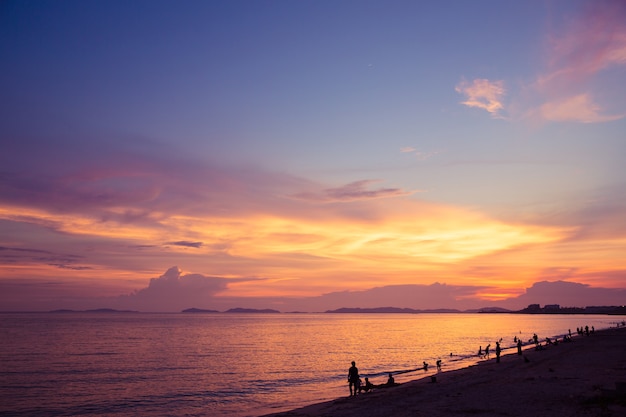 Puesta de sol playa y crepúsculo cielo con silueta relajante turista