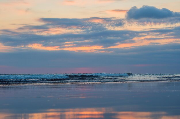 Puesta de sol en la playa de Kuta con reflejo en el agua en la isla de Bali