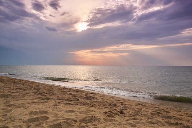 Puesta de sol y puesta de sol en la playa. Cielo dramático con nubes