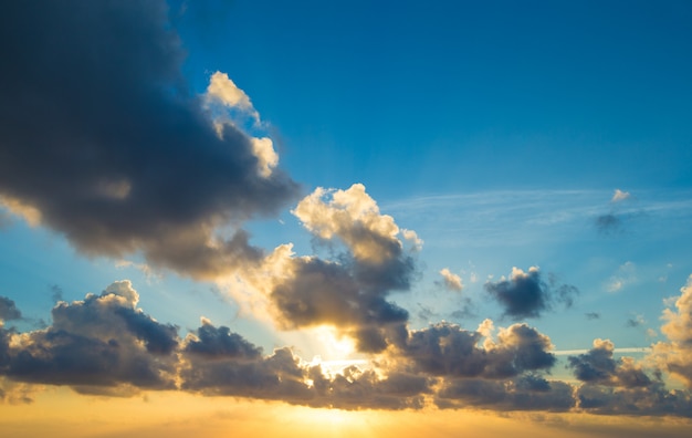 Puesta de sol con rayos de sol, cielo con nubes y sol