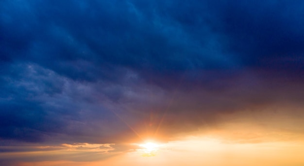 Puesta de sol con rayos de sol cielo con nubes y sol