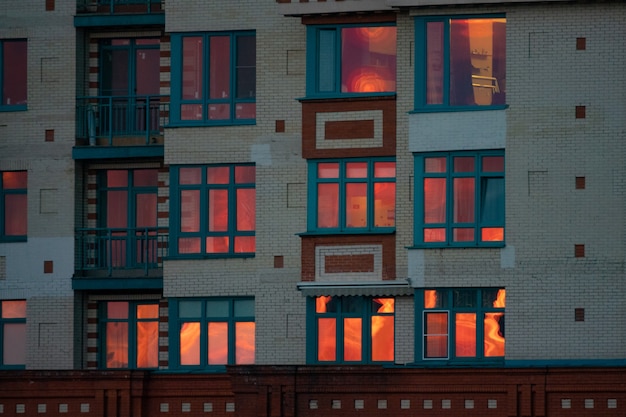 La puesta de sol se refleja en las ventanas de la casa Edificio de varios pisos al atardecer Moscú