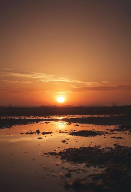 Una puesta de sol con un reflejo de una puesta de sol en el agua