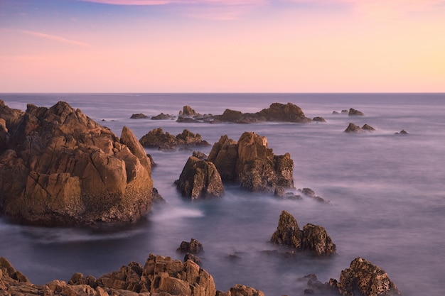 Puesta de sol entre las rocas de la costa gallega.