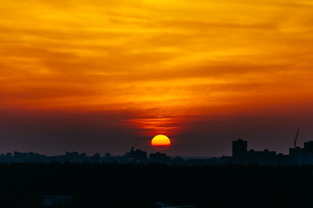 Puesta del sol roja y amarilla sobre la ciudad cubierta por las nubes sobre Minsk, Bielorrusia.