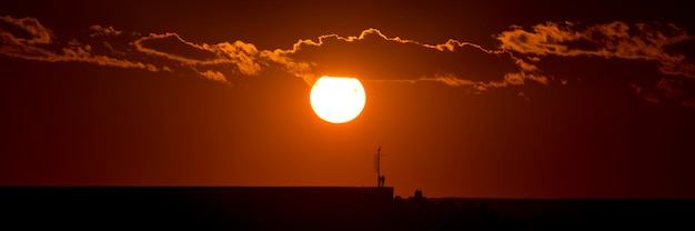 Puesta de sol roja, cielo nublado