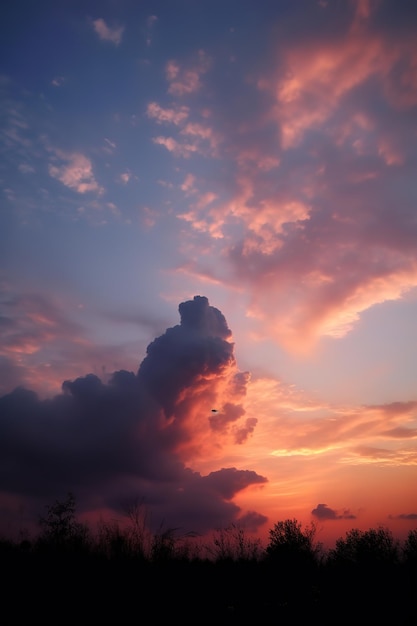 Una puesta de sol rosa con una nube de colores.