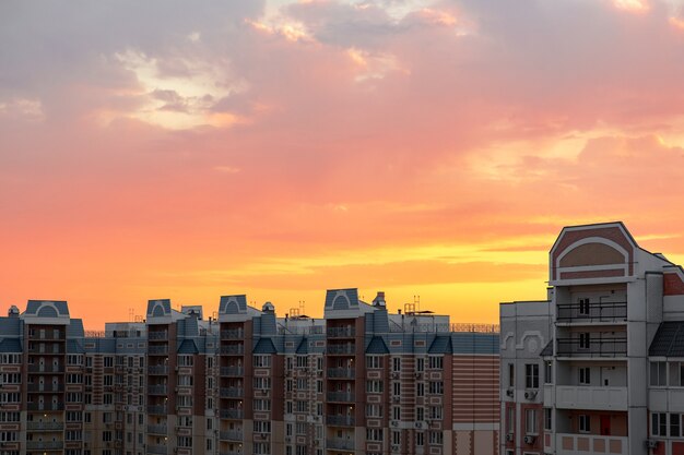 Puesta de sol en rosas y naranjas brillantes. Modernos edificios nuevos al atardecer.Rascacielos y vista del cielo