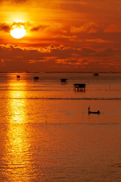 Puesta de sol sobre el agua con cielo nublado