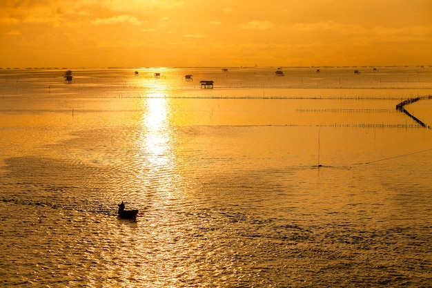 Puesta de sol sobre el agua con cielo nublado