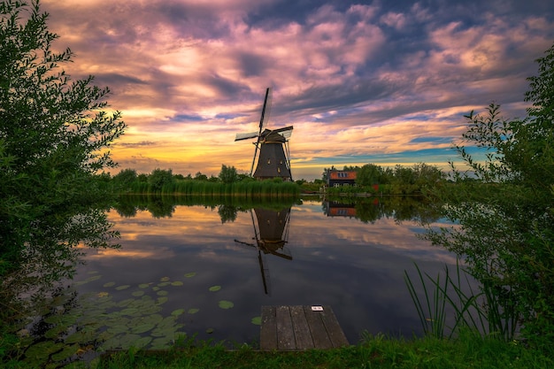 Puesta de sol sobre el antiguo molino de viento holandés en kinderdijk países bajos