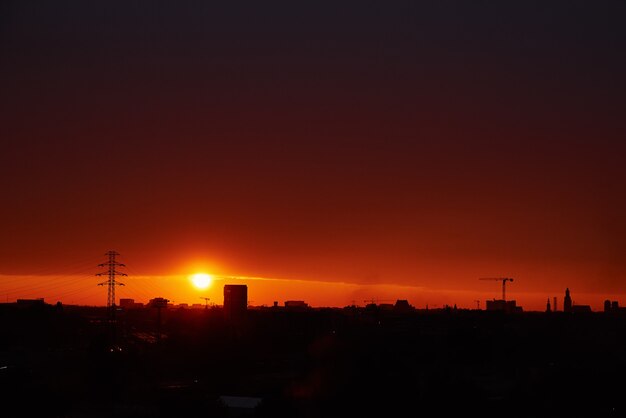 Puesta de sol sobre la ciudad con silueta de edificios