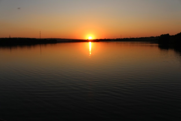 Una puesta de sol sobre un cuerpo de agua.