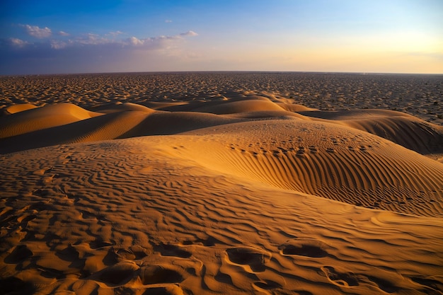 Puesta de sol sobre las dunas de arena del desierto árabe en omán