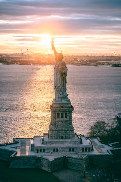 Foto puesta de sol sobre la estatua de la libertad