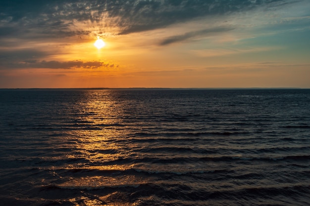 Puesta de sol sobre un gran lago Puesta de sol en un gran lago con cielo amarillo y agua