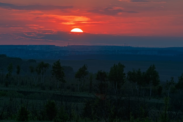 Puesta de sol sobre el horizonte en un cielo nublado.