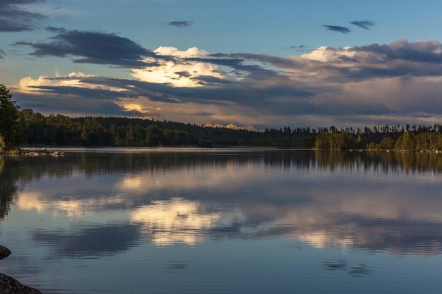 La puesta de sol sobre el lago con algunas nubes interesantes en el cielo