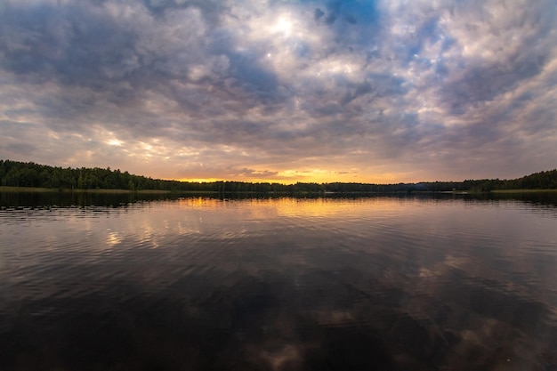 Puesta de sol sobre el lago del bosque