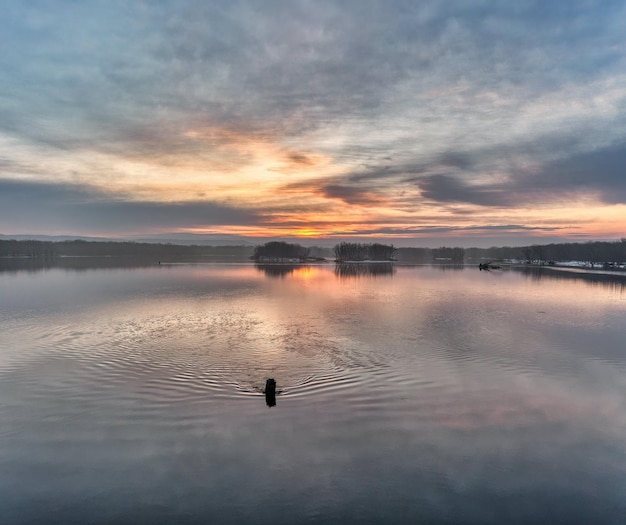 La puesta de sol sobre el lago Foto