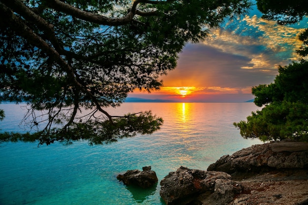 Puesta de sol sobre el mar Adriático en un pequeño pueblo de Brela, Croacia