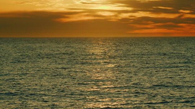 Foto puesta de sol sobre el mar sol reflejado en el rayo del mar y amanecer o puesta de sol sobre un mar tranquilo en tiempo real