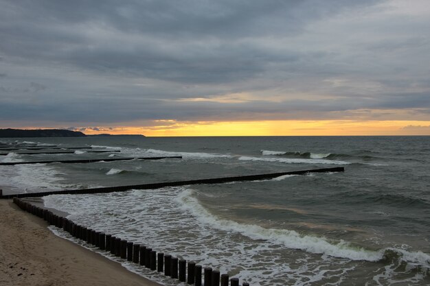 puesta de sol sobre el mar en tiempo tormentoso con reflejos rojos en el horizonte