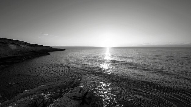 Una puesta de sol sobre el océano con una foto en blanco y negro