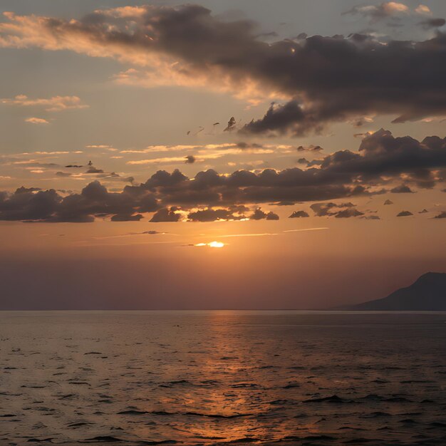 una puesta de sol sobre el océano con una montaña en el fondo