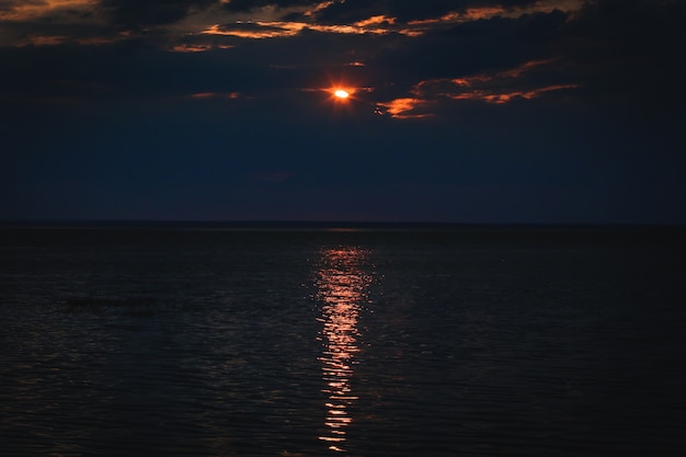 Puesta de sol sobre reflejo de agua y rayos