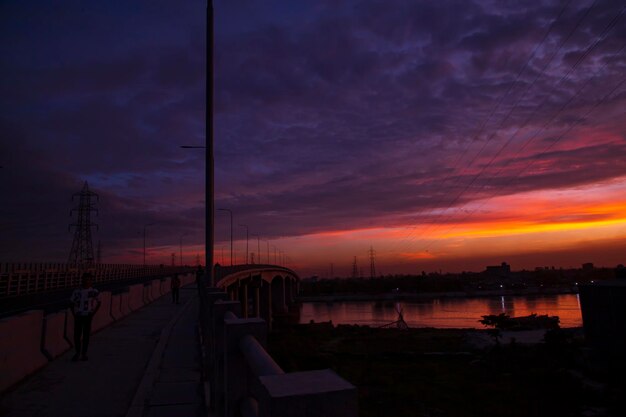 Puesta de sol sobre el río en la ciudad El puente cruza el río