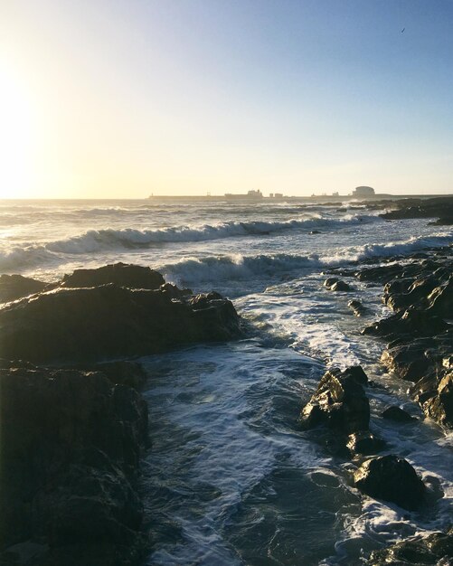 Puesta de sol sobre las rocas y las olas del océano Atlántico cerca de Porto Portugal abril 2019