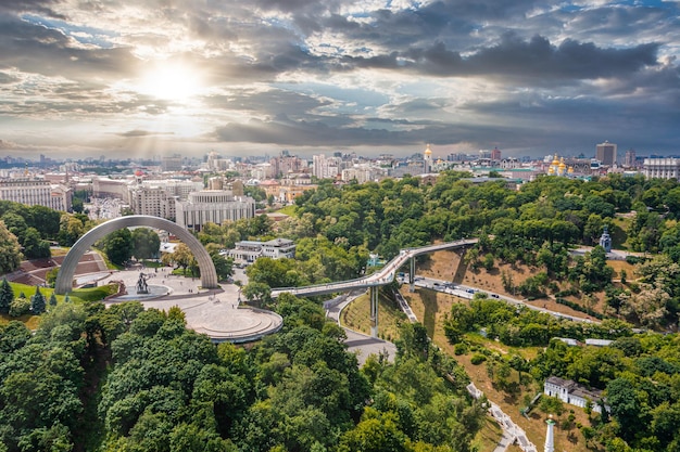 Puesta de sol sobre el verano de kiev con arco de amistad de los pueblos