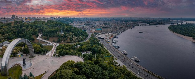 Puesta de sol sobre el verano de kiev con arco de amistad de los pueblos