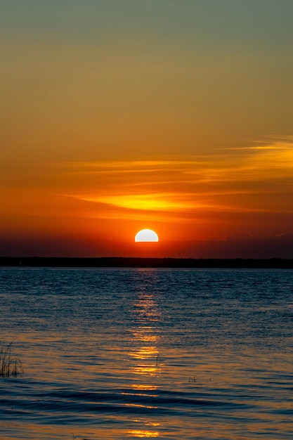 Una puesta de sol con un sol amarillo en el cielo.