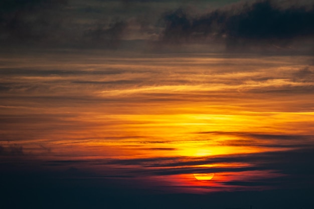 Una puesta de sol con el sol poniéndose detrás