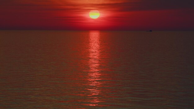 La puesta de sol tropical en la playa colorea el océano, el cielo y las olas en rojo.