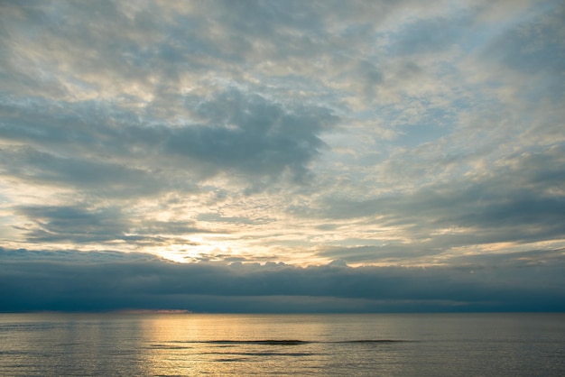 Puesta de sol de verano en la playa con nubes sobre el cielo