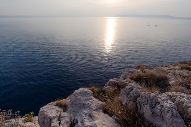 Puesta de sol en la vista del mar Adriático desde la costa rocosa.