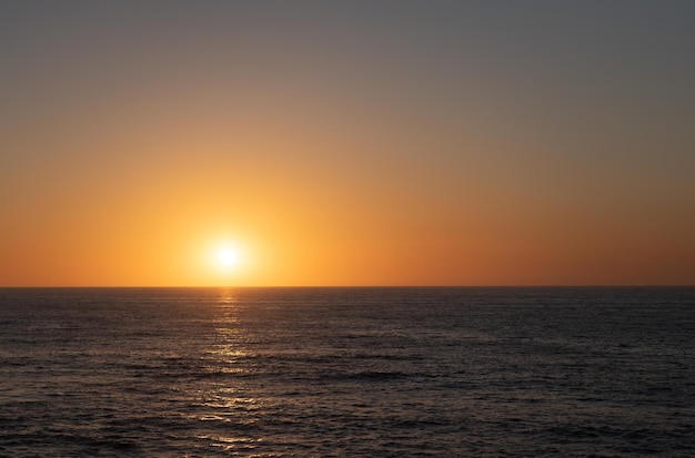 Puesta de sol vista romántica con horizonte y agua de mar