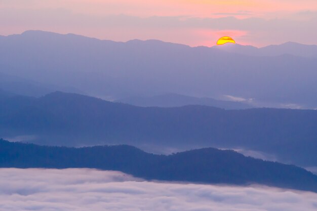 puesta de sol con vistas a las montañas con niebla