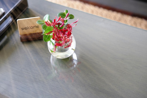 Puesto de etiqueta de bienvenida con jarrón de agua de flores en la mesa para el concepto de recepción de bienvenida