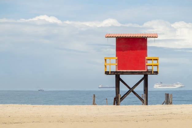 Puesto de socorrista rojo en la playa de copacabana con el mar y el cielo azul en Río de Janeiro.