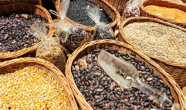 En los puestos del mercado frijoles, lentejas, guisantes, garbanzos. Ardillas veganas. Mercado de alimentos frescos saludables orgánicos. Hierba verde borrosa en el fondo. Dieta vegetal.