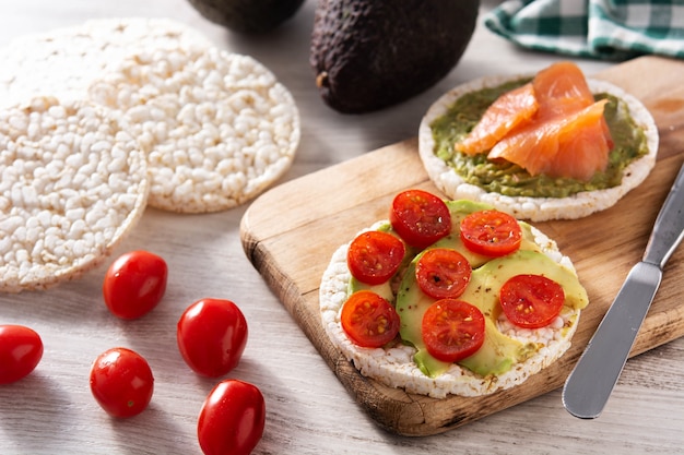 Puffreiskuchen mit Avocado und Tomate auf Holztisch