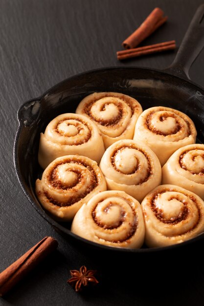 Puffy Teig des Lebensmittelkonzeptes von selbst gemachten Zimtgebäck hob in Pfanne Roheisenpfanne an