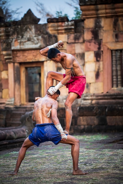 Pugilistas tailandeses têm um estilo de luta forte e o fundo é um antigo castelo.