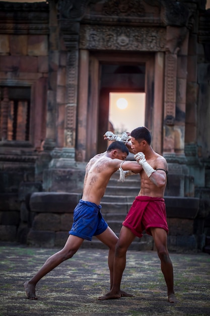 Pugilistas tailandeses têm um estilo de luta forte e o fundo é um antigo castelo.